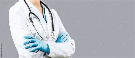 Female Doctor With Crossed Hands Over Grey Background Impersonal No