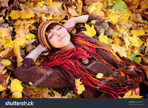 Smiling Happy Girl Portrait Lying In Autumn Leaves Outdoor Stock