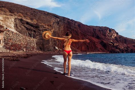 Sexy Woman In Bikini Walks On Red Beach In Santorini By Sea Girl Runs And Jumps Having Fun