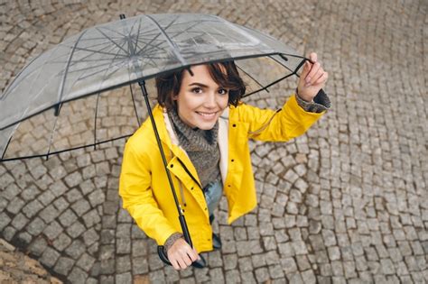 Foto De Cima Da Mulher Maravilhosa Na Capa De Chuva Amarela Sendo Feliz