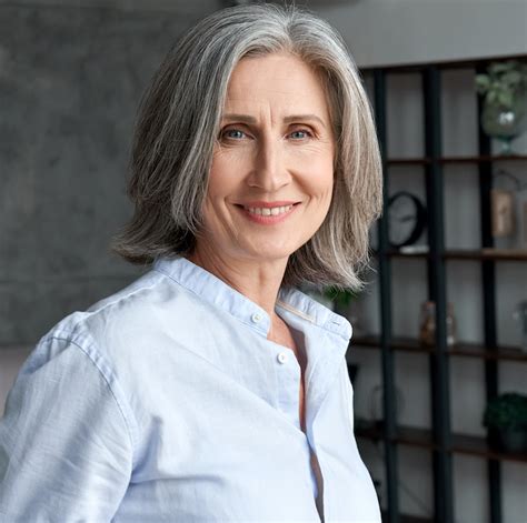 Smiling Confident Middle Aged Grey Haired Woman Standing In Office