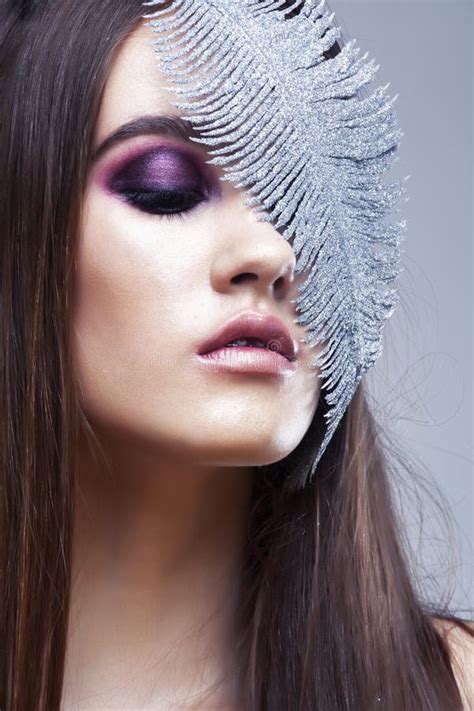 Brunette De Belleza Jovencita Con Maquillaje De Moda Y Plumas De Plata Cerradas En Fondo Blanco