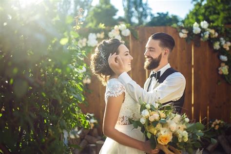 Elegante pareja de felices recién casados posando al sol linda novia y