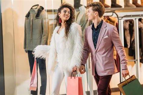 Stylish Young Multiethnic Couple With Shopping Bags Walking Together