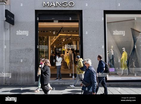 Pedestrians walk past the Spanish multinational clothing brand Mango ...