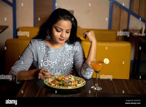 Portrait Of A Pretty Woman Eating Delicious Food In A Restaurant Stock