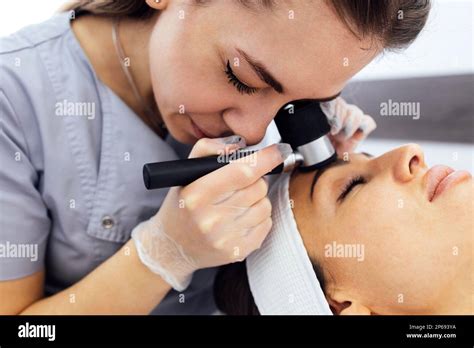 Doctor Dermatologist Examines Skin Of Client Face Of Beauty Salon With