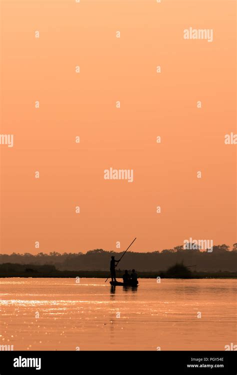 Men In A Boat On A River Silhouette With Sunset Light Stock Photo Alamy