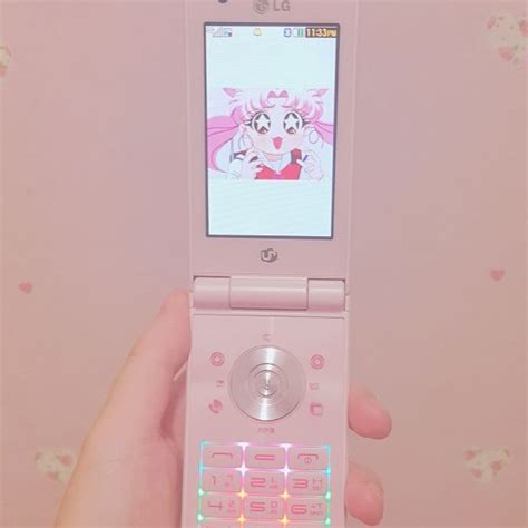 A Person Holding A Pink Cell Phone In Their Left Hand With An Animated Character On The Screen