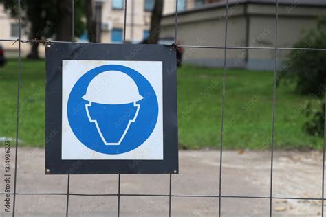 Safety helmet must be worn.Construction sign on the metal fence Stock ...