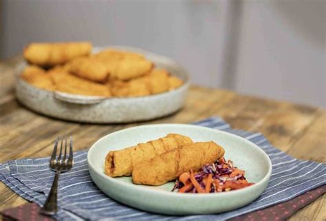 Some Food Is On A White Plate And Next To A Bowl Of Chicken Nuggies