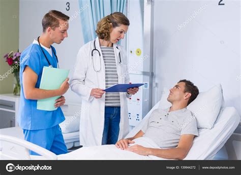 Doctors talking to patient in hospital bed Stock Photo by ...