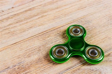 Green Fidget Spinner On A Wood Premium Photo