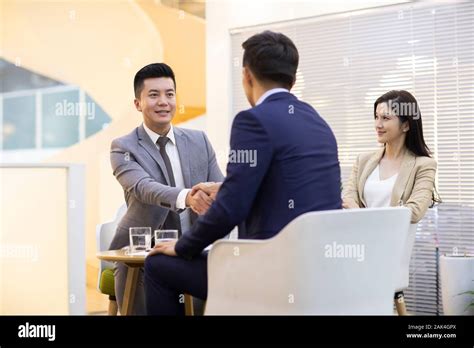 Chinese Business People Shaking Hands In Office Stock Photo Alamy