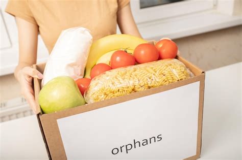 Premium Photo Caring For The Orphans A Volunteer Girl Holds A Box Of