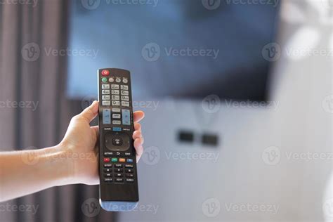 hand using remote controller for adjust Smart TV inside the modern room ...