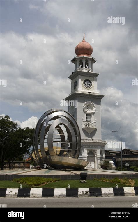 Queen Victoria Clock Tower Next To A Betel Nut Sculpture At Penang