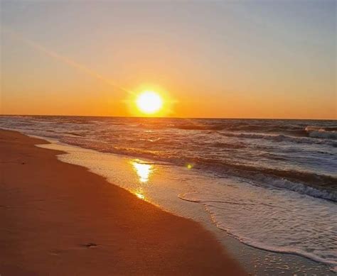 The Sun Is Setting Over The Ocean At The Beach