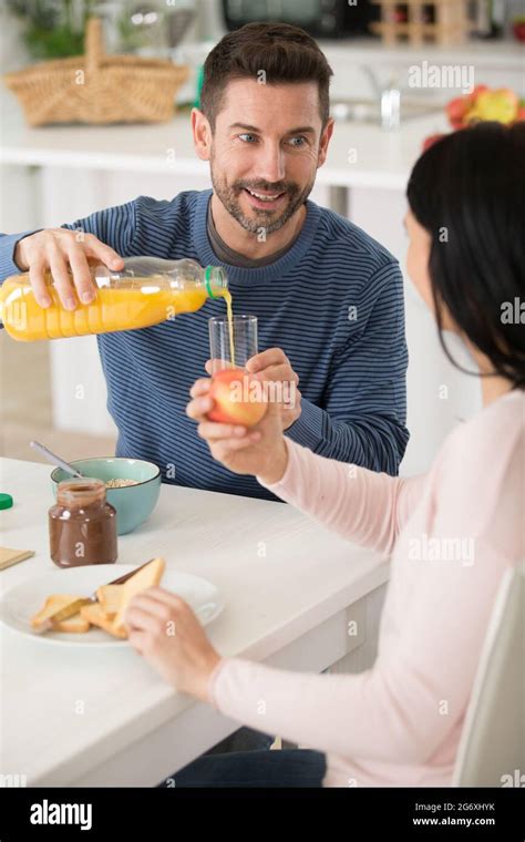 Man Pouring Orange Juice From Bottle Into Glass Stock Photo Alamy