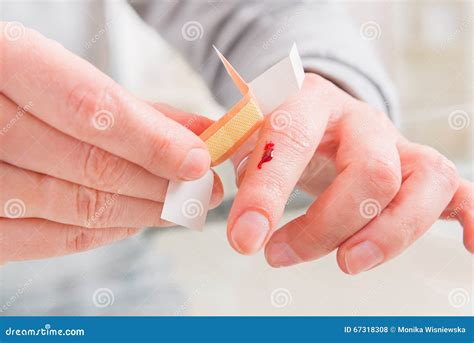 Applying Adhesive Bandage On Finger Stock Photo - Image: 67318308