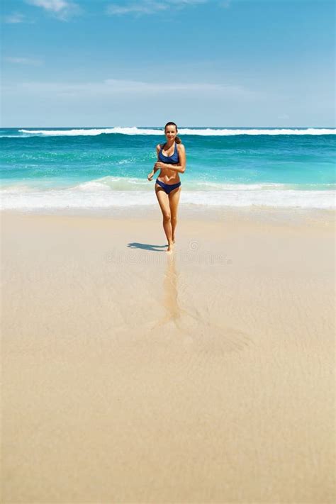 Funcionamiento De La Playa Mujer De La Aptitud En El Bikini Que Corre