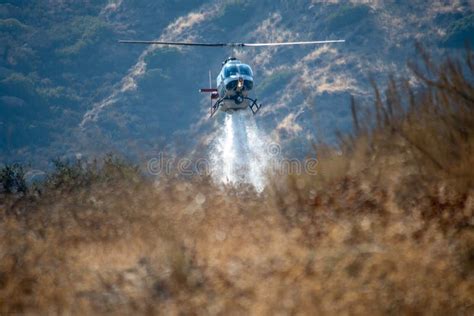 A Lafd Bell 206 Helicopter Makes A Water Drop On A Brush Fire In