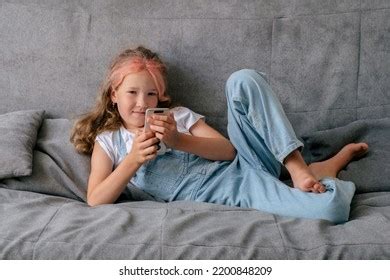 Little Girl Lying On Couch Using Stock Photo 2200848209 | Shutterstock