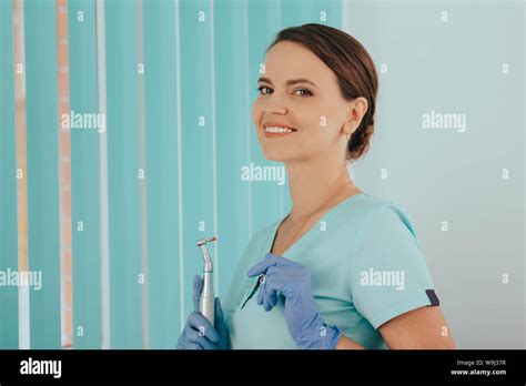 Portrait Positive Beautiful Female Dentist With Dental Drill At Dental