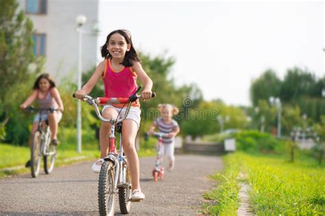 Tres Niños Felices Que Montan En La Bicicleta Imagen de archivo