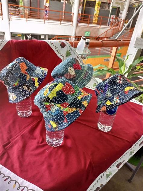 Three Glass Vases With Hats On Them Sitting On A Red Cloth Covered