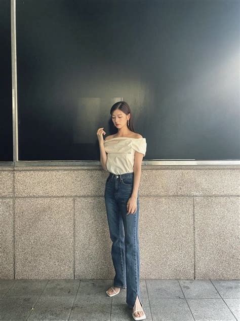 A Woman Standing In Front Of A Chalkboard With Her Hand On Her Hip And