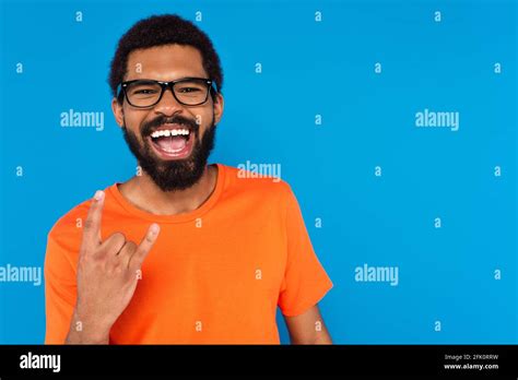 African American Man In Glasses Smiling And Showing Rock Sign Isolated