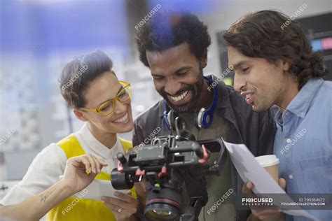 Smiling journalists and cameraman using digital camera — Creative Business, equipment - Stock ...