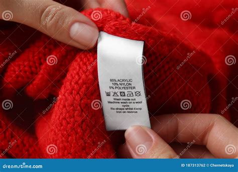 Woman Reading Clothing Label With Care Symbols And Material Content On