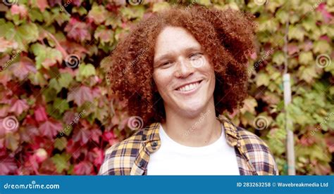 Portrait Of Happy Biracial Man With Curly Red Hair And Freckles Smiling