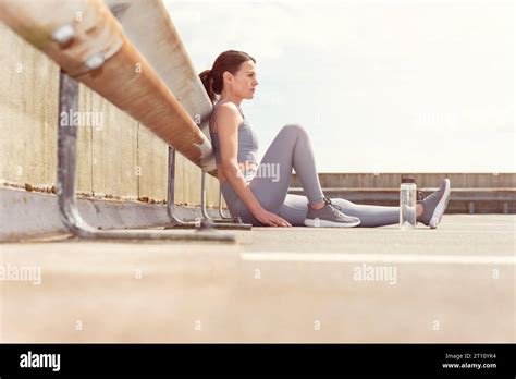 Sporty Female Runner Sitting Resting After Exercise Urban Background