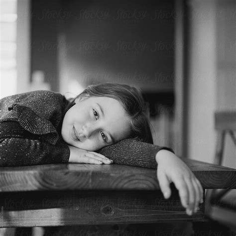 Black And White Portrait Of A Pretty Young Girl Laying On A Kitchen