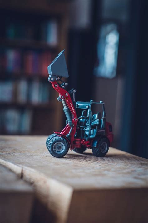 A Toy Tractor With A Large Piece Of Equipment On It S Back End Sitting