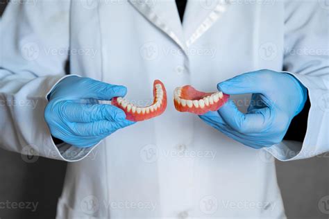 prótese dentária nas mãos do médico close up dentista segurando a