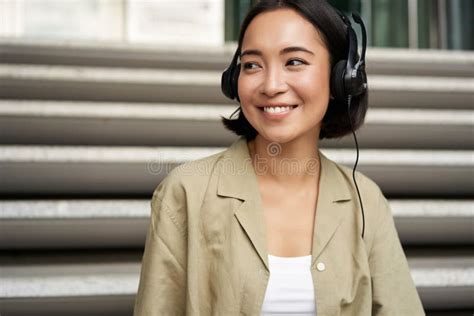 Portrait Of Beautiful Girl In Earphones Listening Music Smiling And