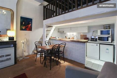 A Kitchen And Dining Room With An Open Staircase Leading Up To The Loft