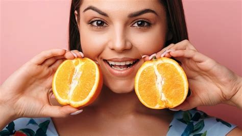 Premium Photo Young Caucasian Woman Holding Orange Fruits And Smiling