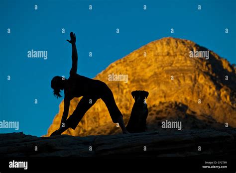 A Fit Young Woman Practicing Yoga While On A Rock Climbing Trip Red