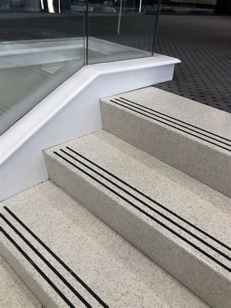 The Stairs Are Made Of Concrete And Have Glass Railings