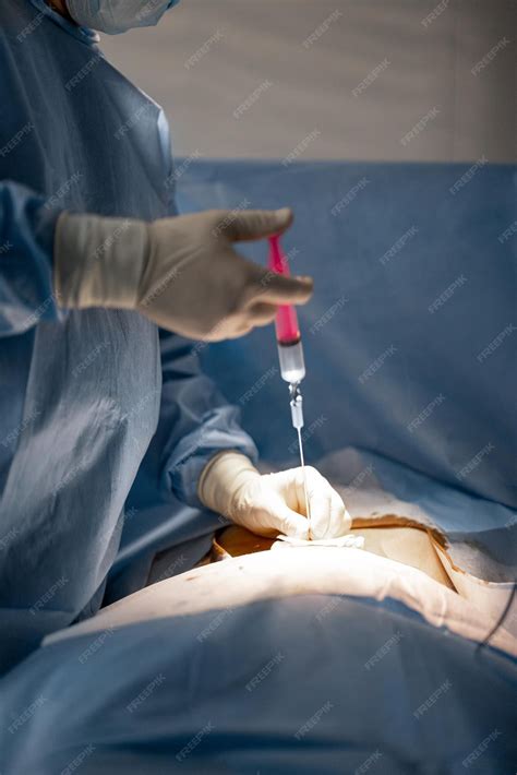 Premium Photo | Surgeon makes an injection during an operation