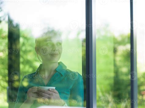 young woman drinking morning coffee by the window 10828739 Stock Photo