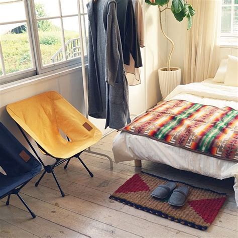 A Bed Room With A Neatly Made Bed And Two Chairs Next To Each Other On