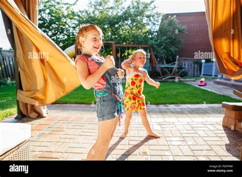 Portrait Of Two Little Girls Sisters Having Fun On Home Backyard