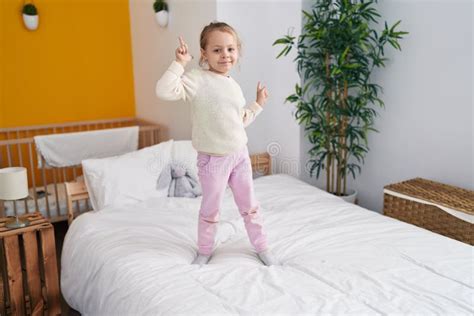 Adorable Blonde Girl Smiling Confident Standing On Bed At Bedroom Stock Photo Image Of Pyjama