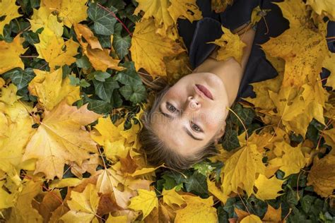 Portrait Of Young Beautiful Girl Lying On The Autumn Leaves Stock